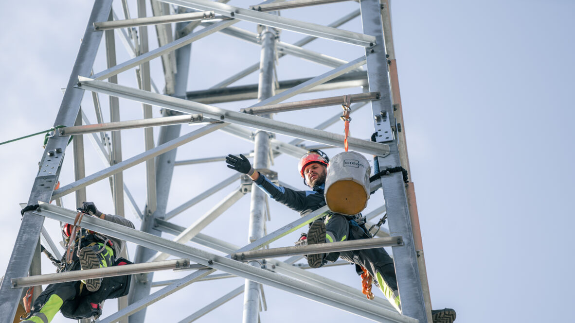 Sicher arbeiten in der Höhe: Cteam Mitarbeiter am Gittermast für Netzausbau.
