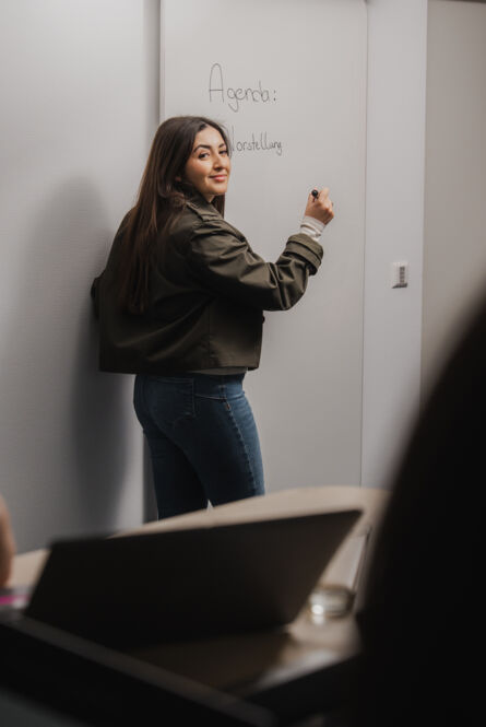 Cteam consultant presenting agenda on whiteboard, illustrating clear communication in projects. Cteam consultant presenting agenda on whiteboard, illustrating clear communication in projects.