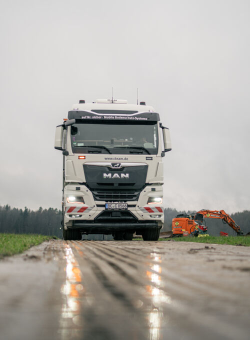 Mobiles Bodenschutzsysteme von Cteam im Einsatz: MAN LKW und Bagger auf matschigem Untergrund.