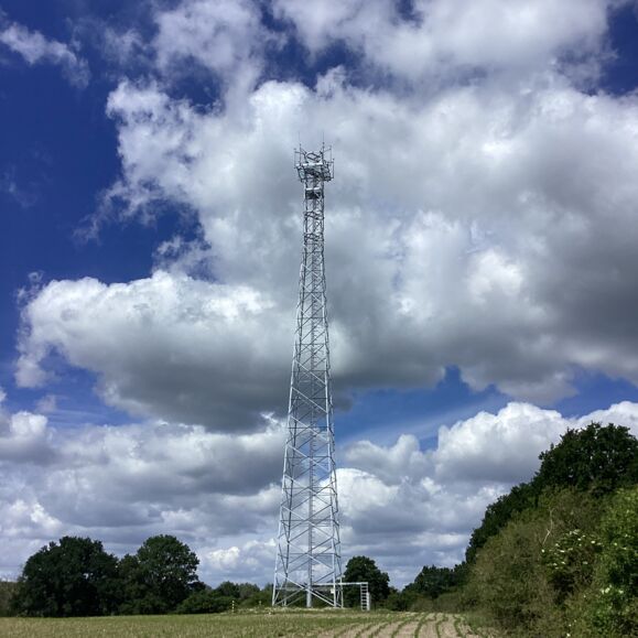 Telekommunikationsturm unter bewölktem Himmel, symbolisch für Cteam-Infrastrukturprojekte.