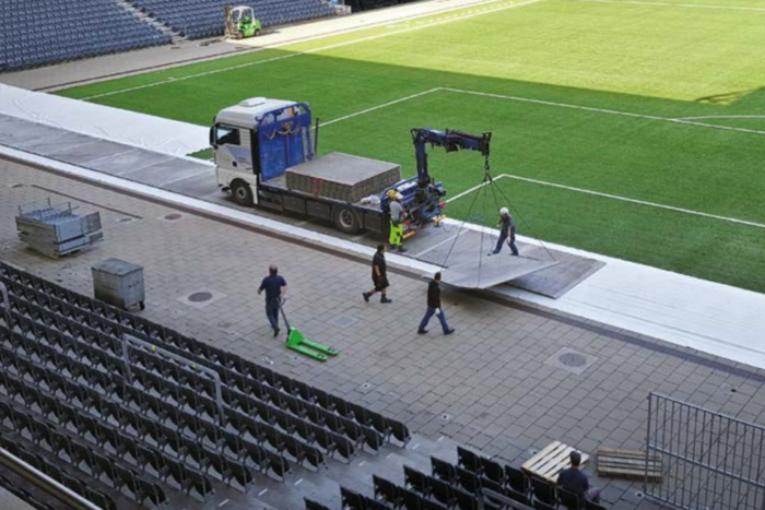 Cteam: Heavy infrastructure panel installation underway at a stadium.